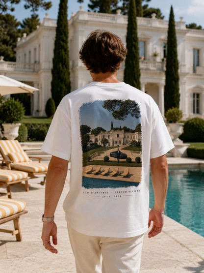 Homme de dos portant le t-shirt Cap d'Antibes Hustle Wear devant une villa avec piscine