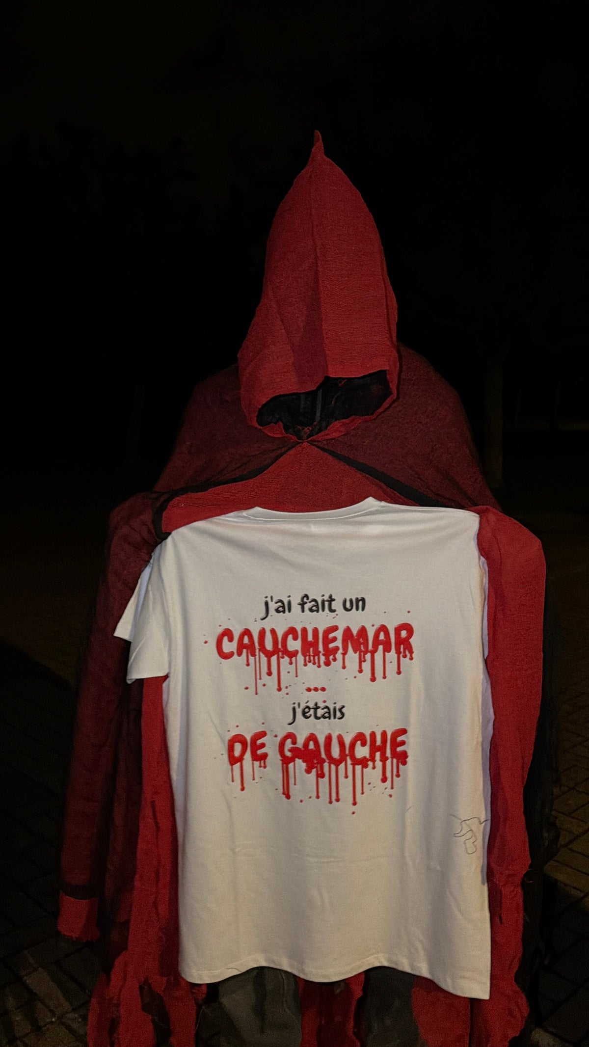 Gros plan du t-shirt Halloween J'ai fait un cauchemar édition sang sur un épouvantail en cape rouge, coloris blanc
