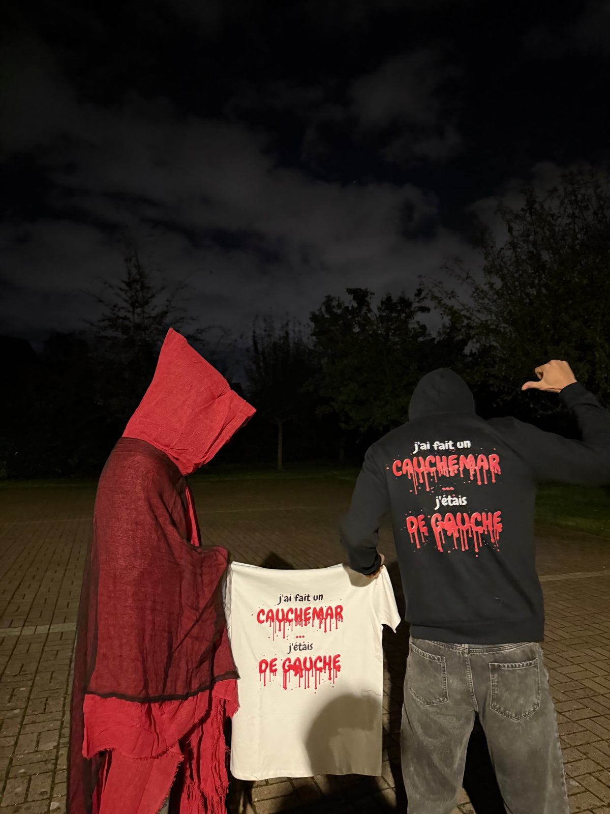 T-shirt Halloween édition sang tenu devant une cape rouge, pull noir de dos, de nuit, coloris blanc