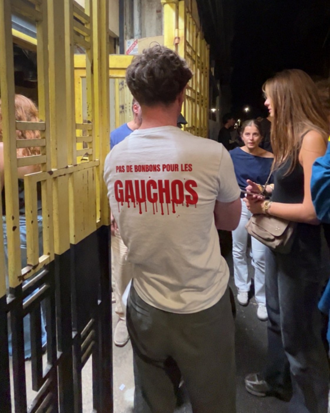 T-shirt blanc Pas de bonbons pour les gauchos porté de dos sur une terrasse en soirée, coloris blanc