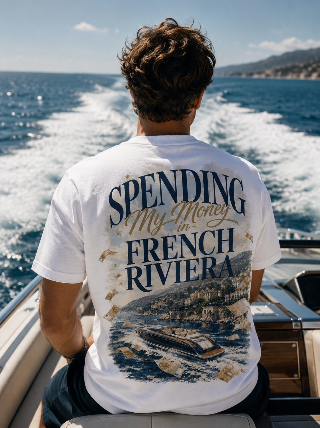 Homme de dos portant le t-shirt Spending My Money in French Riviera Hustle Wear sur un hors-bord